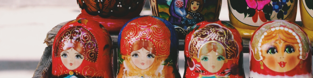 Picture of rows of babushka dolls lined up next to each other, in beautiful red and orange tones