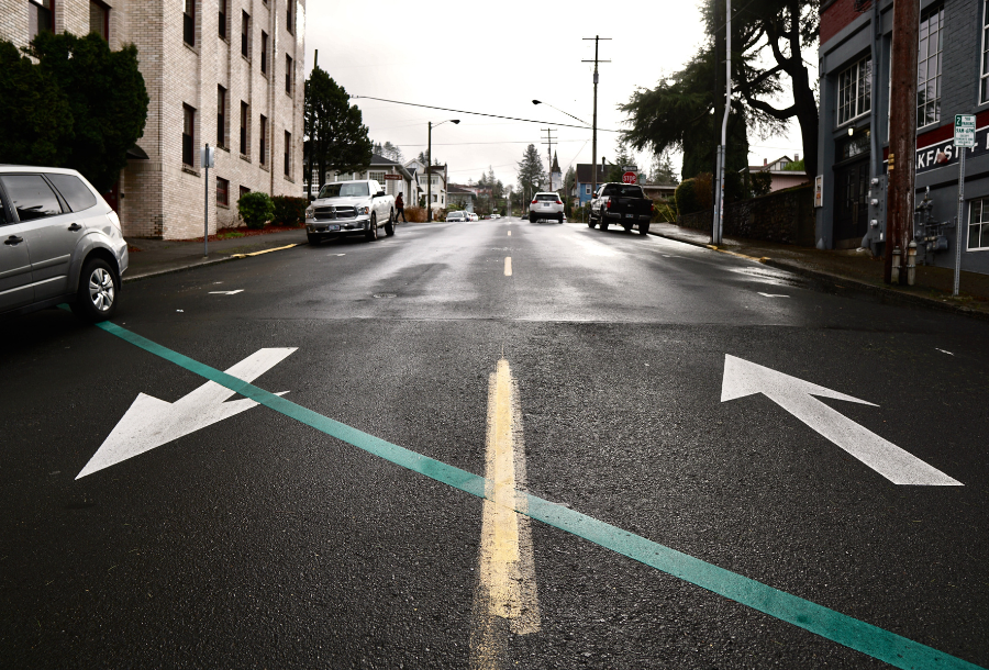Picture of a road, with an arrow going towards the photo on the left hand side and on the right hand side an arrow going up the street