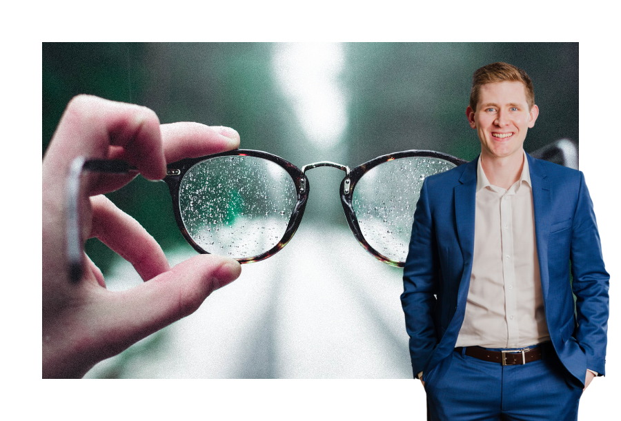 Pictured, Financial Advisor Chris Graham standing in front of a pair of glasses covered in rain, being held up by a hand looking into the distance of a road