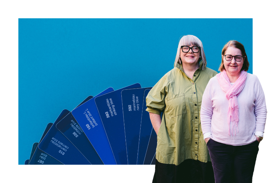 Pictured, Anthea Taylor and Christine Friel standing in front of a dark blue panton fan spread out against a dark blue background.