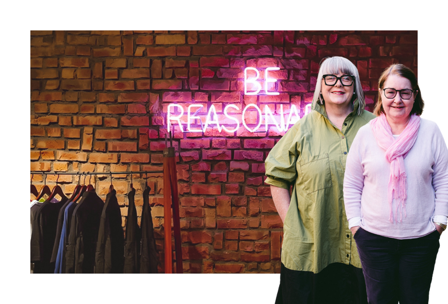 Pictured, Anthea Taylor and Christine Friel standing in front of a stock picture of a brick wall with neon lights lit up in pink saying "be reasonable"