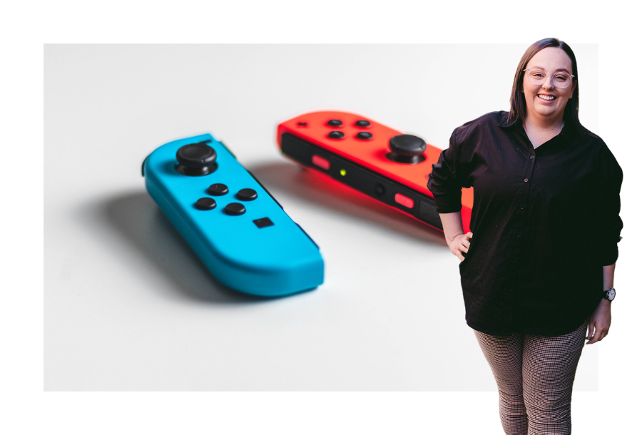 Pictured, Mekayla Lambert standing with one hand on her hip, in front of a stock picture of two Nintendo Switch controllers, one blue and one red.