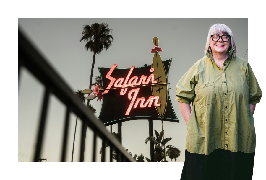 Pictured; Head of Canny Plan Management, Anthea Taylor. Standing in front of a neon hotel sign that reads "Safari Inn"
