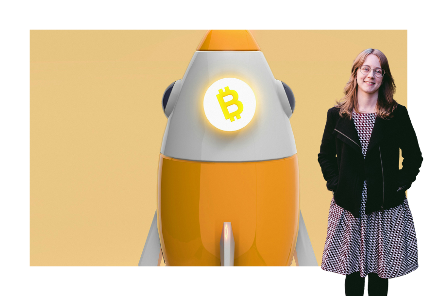 Pictured: Brittany Bell, standing in a colourful dress with a black jacket on, hands in her pockets and smiling. Behind her is an image of a white and yellow simple rocket with the bitcoin glowing logo on it.