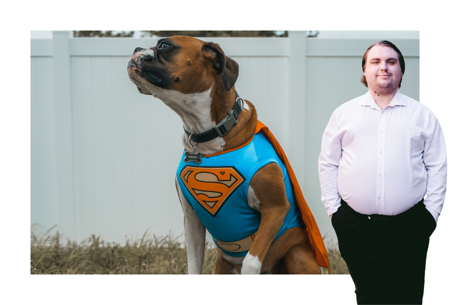 Pictured: Corey Haynes standing smiling with his hands in his pockets, wearing a white button up business shirt and black trousers. Behind him